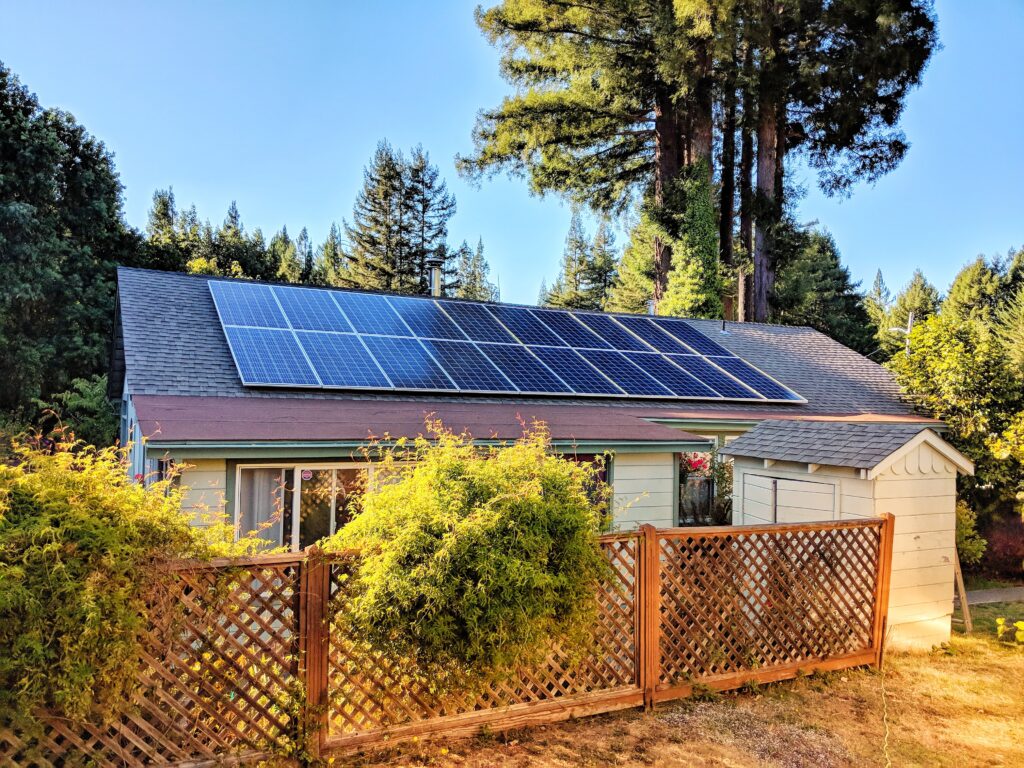 solar panels on house with trees and fence