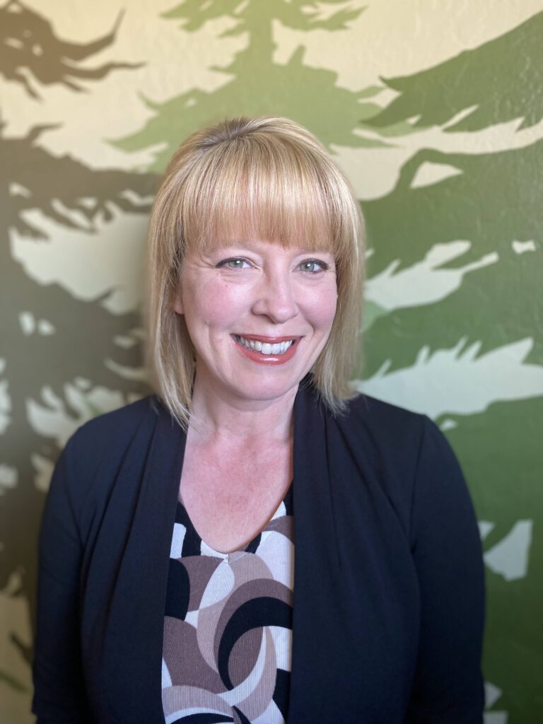 Headshot of SRS staff person in front of tree background