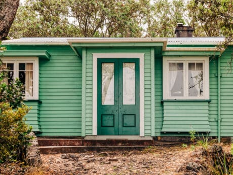 Green mobile home in woods