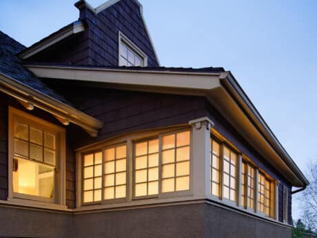 Low angle view of the upper floors of house with lights on at dusk