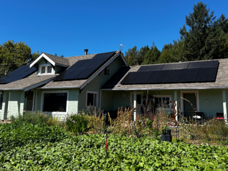 Residential solar system installed by Six Rivers Solar in the North Coast of California with bushes in foreground
